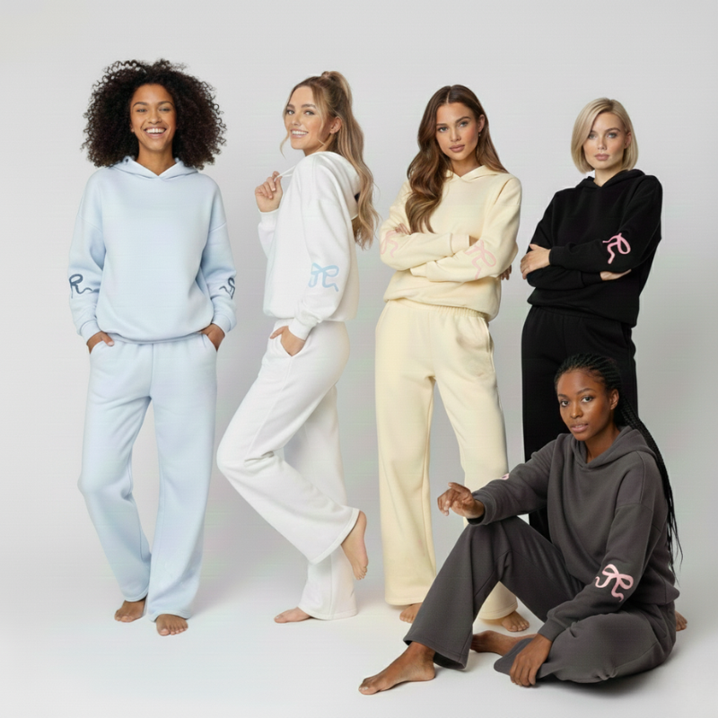 Pięć kobiet w dresach Luna™ Ribbon Tracksuit z Inicala.pl w pastelowych i klasycznych kolorach pozuje razem na jasnym tle, pokazując różne sylwetki i rozmiary w tym samym wygodnym kroju