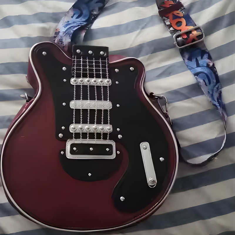 Bordowa Guitarista Torebka Crossbody z czarnym frontem i kolorowym paskiem ROCK lezy na pasiastym kocu detaliczny widok produktu Inicala.pl