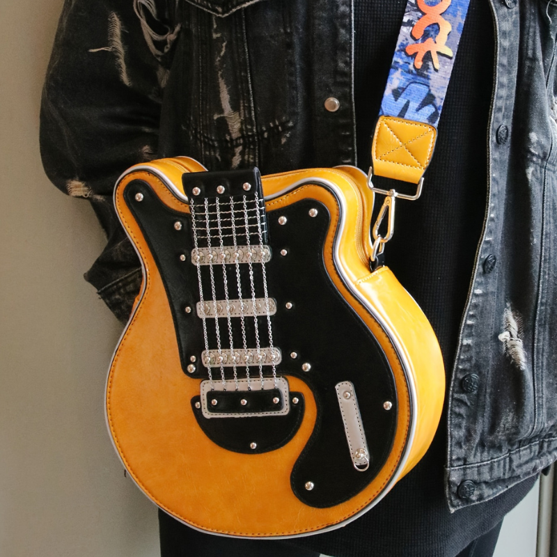 Guitarista torebka crossbody z Inicala.pl w zoltej wersji noszona na ramieniu do czarnej jeansowej kurtki pokazuje rockowy pasek ROCK i detale jak w prawdziwej elektrycznej gitarze