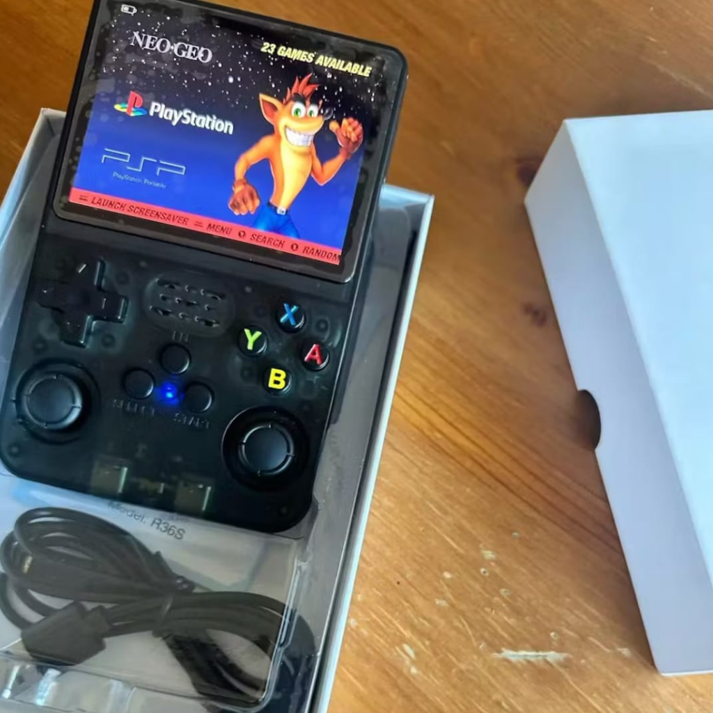 PixelPlay™ Legends od Inicala.pl w czarnej, półprzezroczystej obudowie. Widoczne menu z klasycznymi grami PlayStation. W zestawie kabel USB-C. Kompletna konsola retro gotowa do gry.