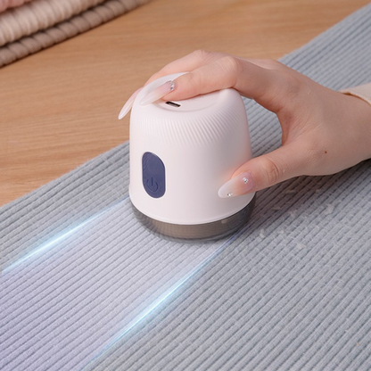 Ręka trzymająca Fuzora™ z Inicala.pl podczas czyszczenia swetra – urządzenie skutecznie usuwa kłaczki i przywraca tkaninom gładkość oraz świeży wygląd